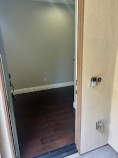 a door open to a room with a hard wood floor